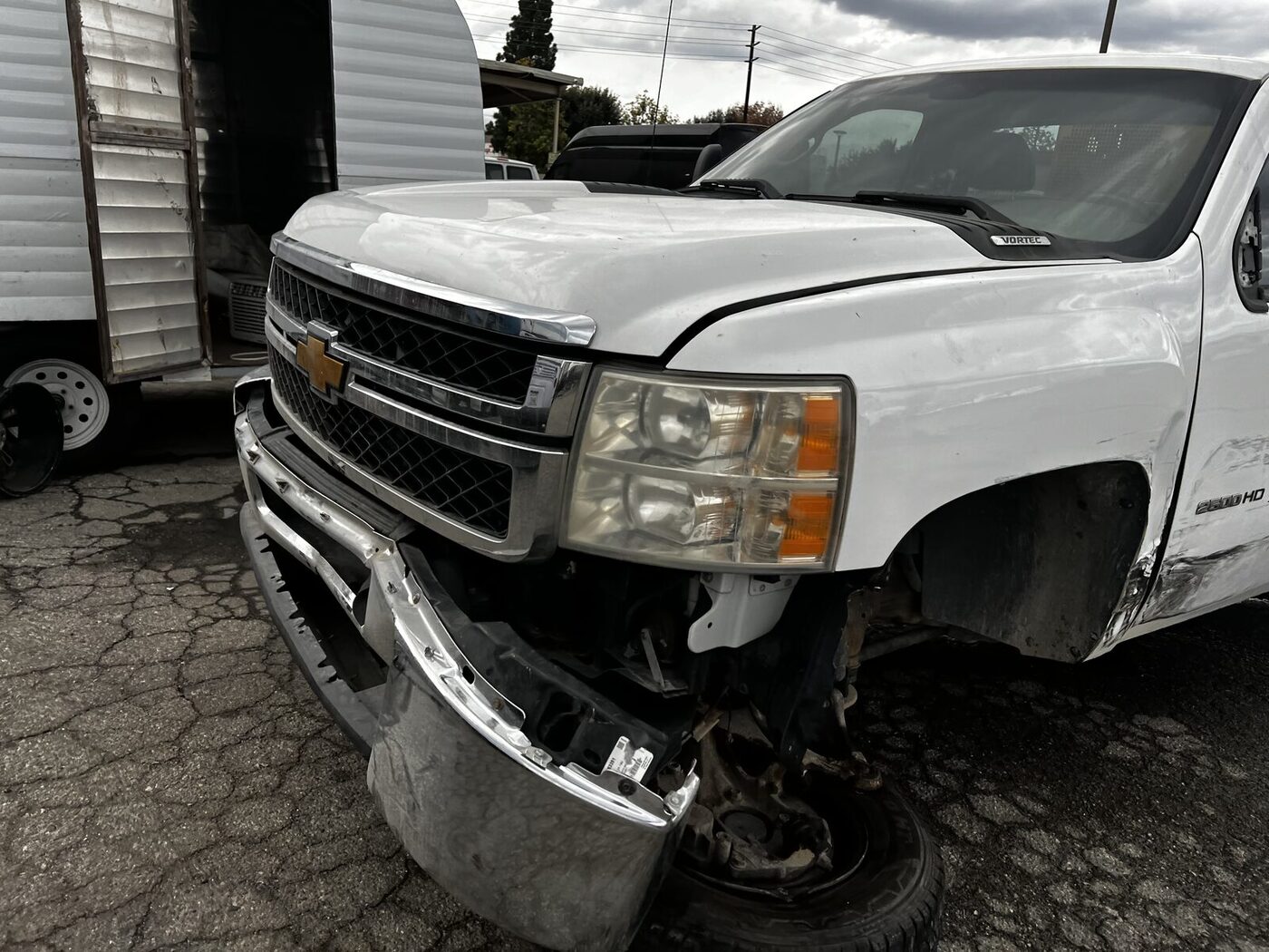 Associated Ready Mixed Concrete Silverado 2500HD with front bumper torn off and fender damage