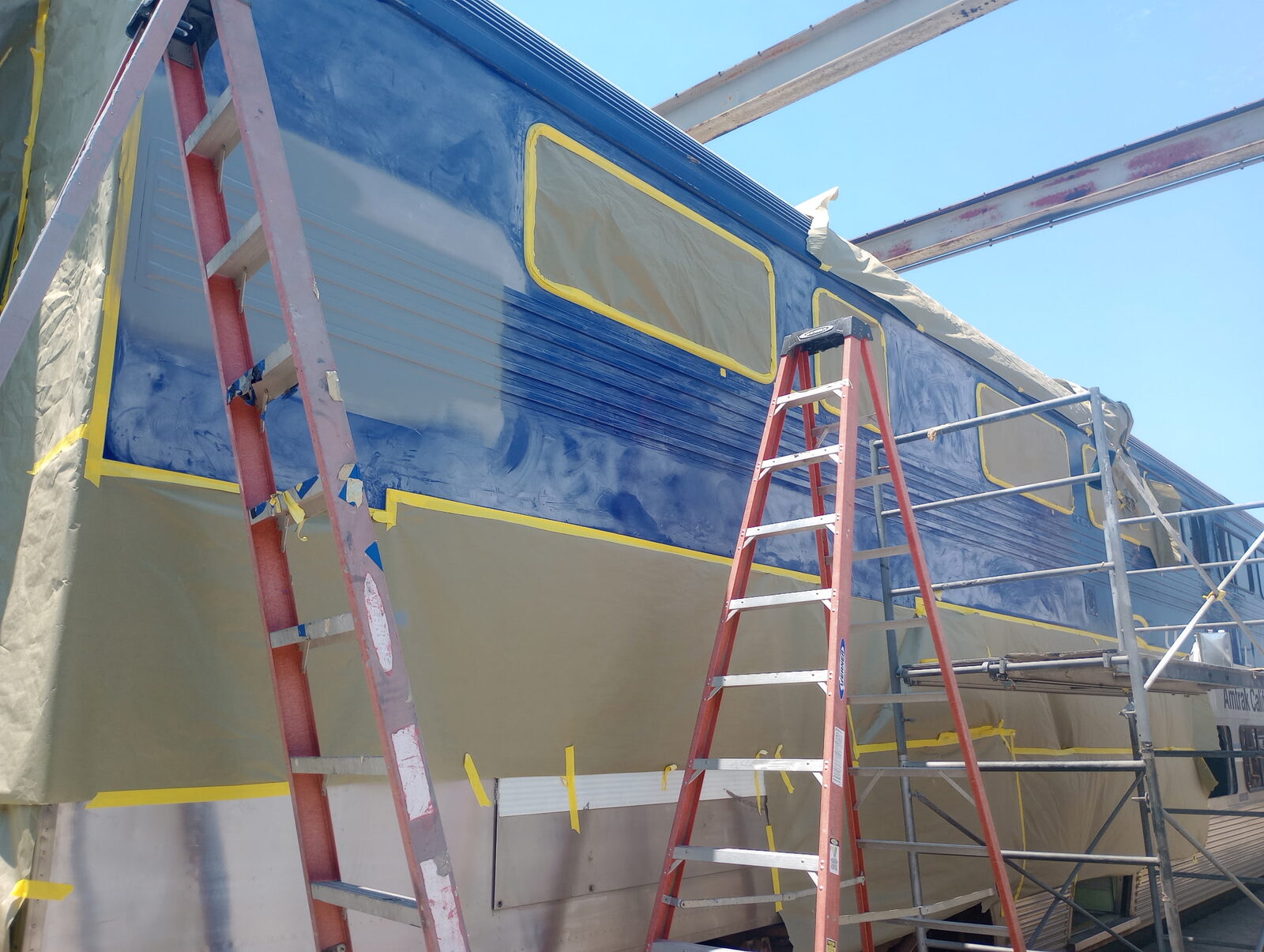 Rail cab car masked and receiving base coat in the paint booth