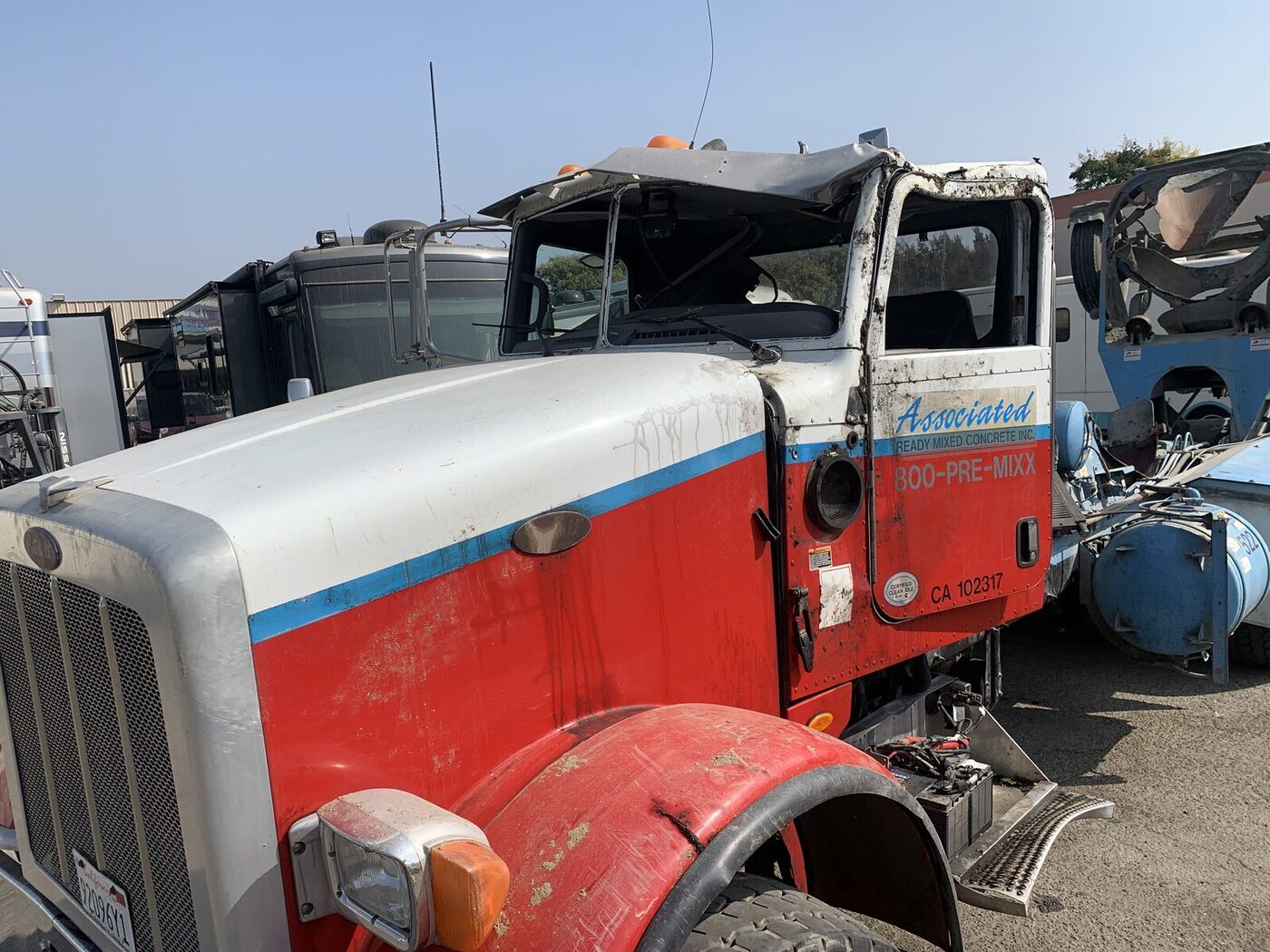 Associated Ready Mixed Concrete Peterbilt with crushed cab roof, damaged door and broken windshield