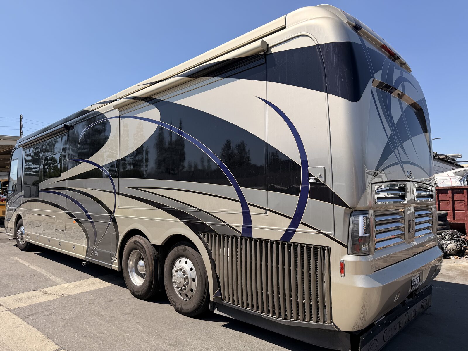 Dark-color diesel pusher motorhome in the shop for fiberglass thermal checking repair on both sidewalls