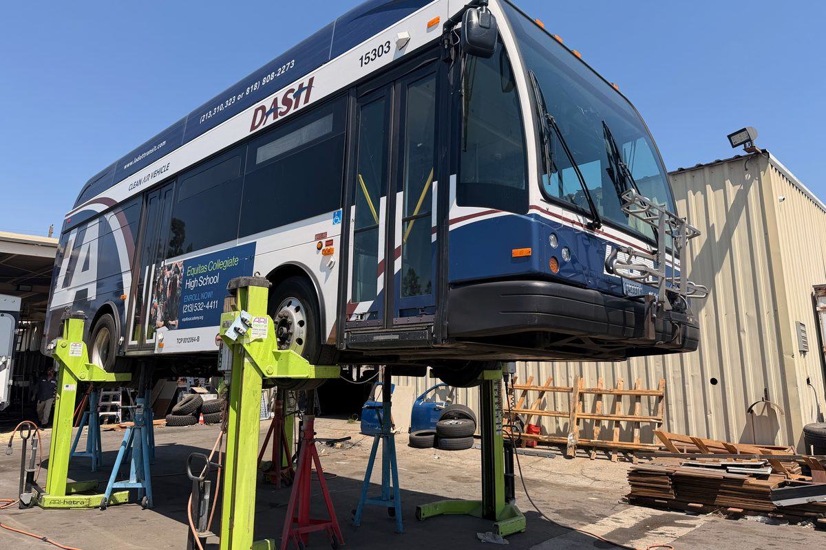 Transit bus raised on lifts for service